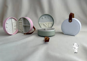 Round leather jewelry organizer with clasp closure and leather handle